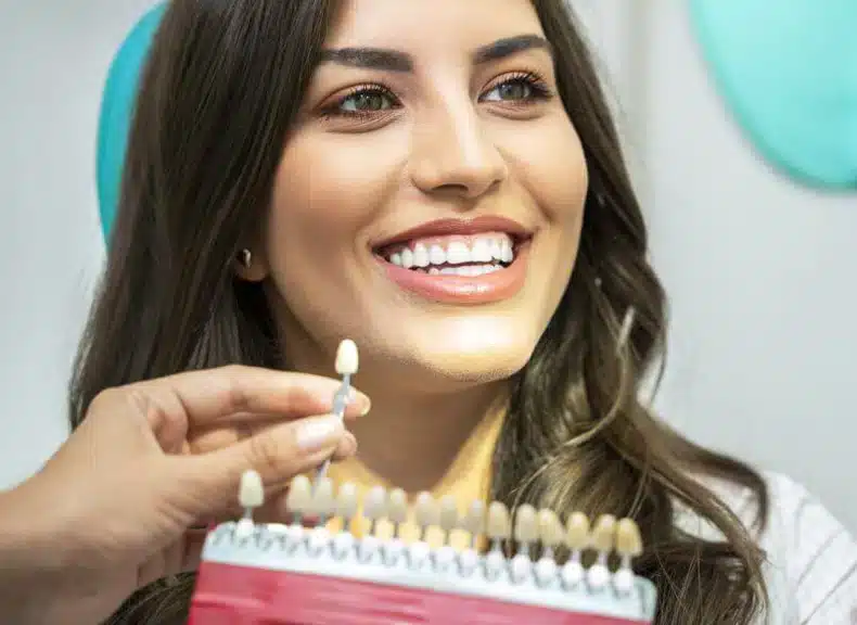 Female patient smiling during porcelain veneer shade matching in Allen