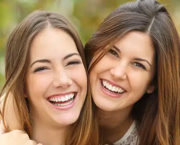 two women smiling with healthy teeth after dental crown treatment in Allen